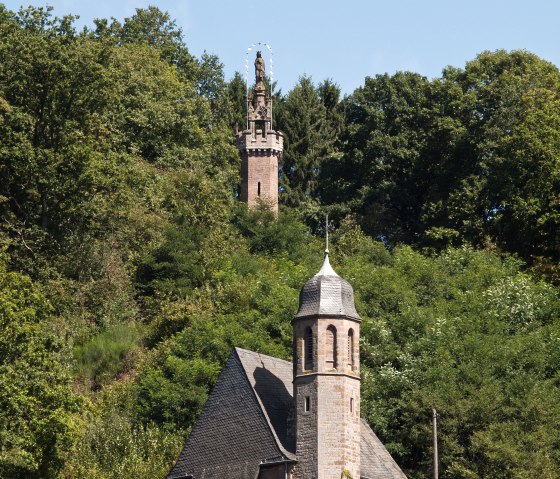 A church with a tower in the foreground, behind it the Marian column on a wooded hill in Kyllburg., © TI Bitburger Land A church with a tower in the foreground, behind it the Marian column on a wooded hill in Kyllburg., © TI Bitburger Land