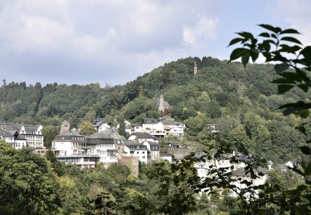 Panoramablick auf Kyllburg mit Häusern und einer Kirche auf einem bewaldeten Hügel unter blauem Himmel., © TI Bitburger Land Panoramablick auf Kyllburg mit Häusern und einer Kirche auf einem bewaldeten Hügel unter blauem Himmel., © TI Bitburger Land