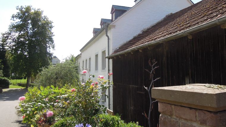 Bauernhaus mit Garten in Dahlem, sonniger Tag.