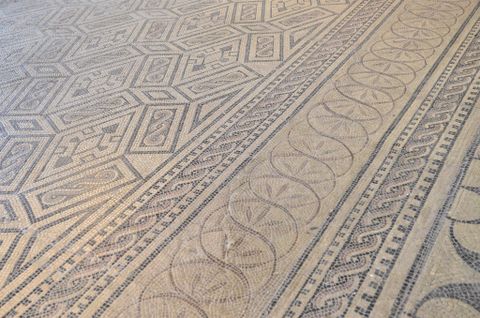 Un mosaïque artistique avec des motifs géométriques et des designs en vagues. La palette de couleurs est discrète et harmonieuse.