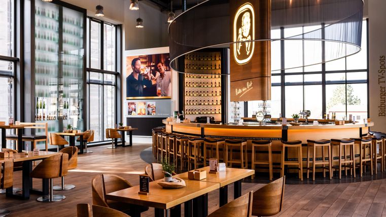Een modern restaurant met een gezellige bar en veel natuurlijk licht. Het interieur is van hout en straalt een gezellige sfeer uit.