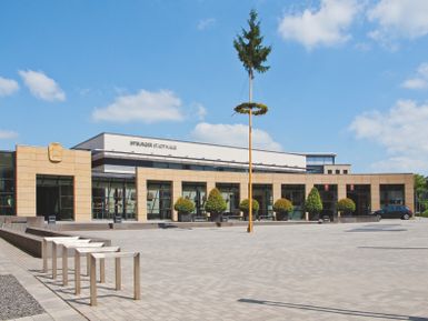 Blick auf die Stadthalle Bitburg mit aufgestelltem Maibaum auf dem Vorplatz