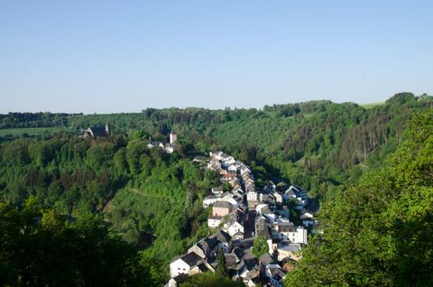 Panoramablick auf Kyllburg mit Kirche und Häusern, umgeben von grünen Wäldern.