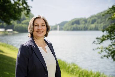 Die Mitarbeiterin Maria Arvanitis von der Tourist-Info Bitburger Land steht vor dem Stausee Bitburg