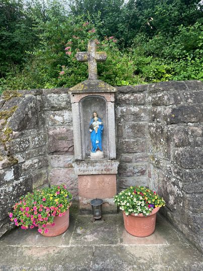 Wegekreuz mit Marienfigur und Blumen in Oberweis.