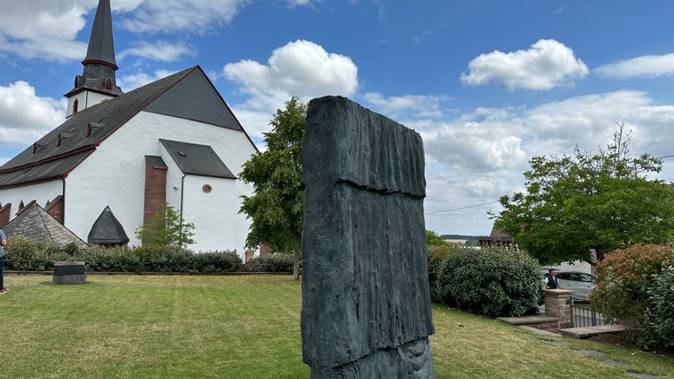 Kirche und Skulptur im Garten der Bibliothek Günther Förg in Weidingen.