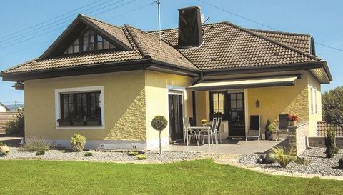 A modern single-family house with a yellow façade and a cozy outdoor area. The garden is well-maintained and invites you to relax.