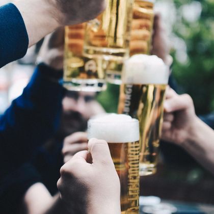 Des personnes trinquaient avec des chopes de bière.