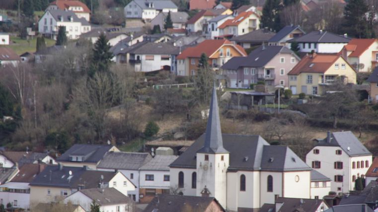 Vue sur le village de Neidenbach avec l'église au premier plan et les maisons à l'arrière-plan.