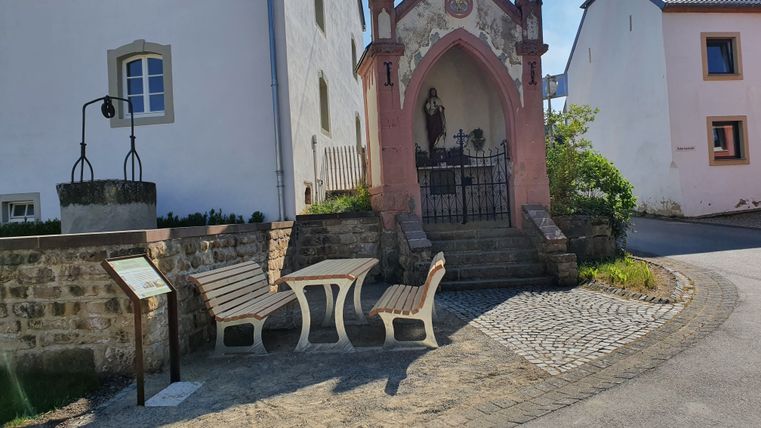 Kleine Kapelle mit Statue und Sitzbank in Wolsfeld.