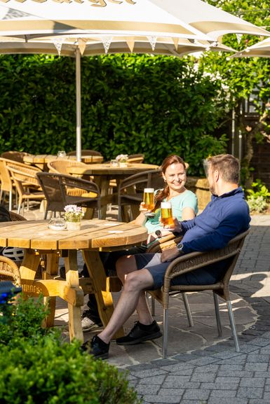 Landgasthaus Keuler. Eine Frau und ein Mann sitzen an einem Gartentisch.