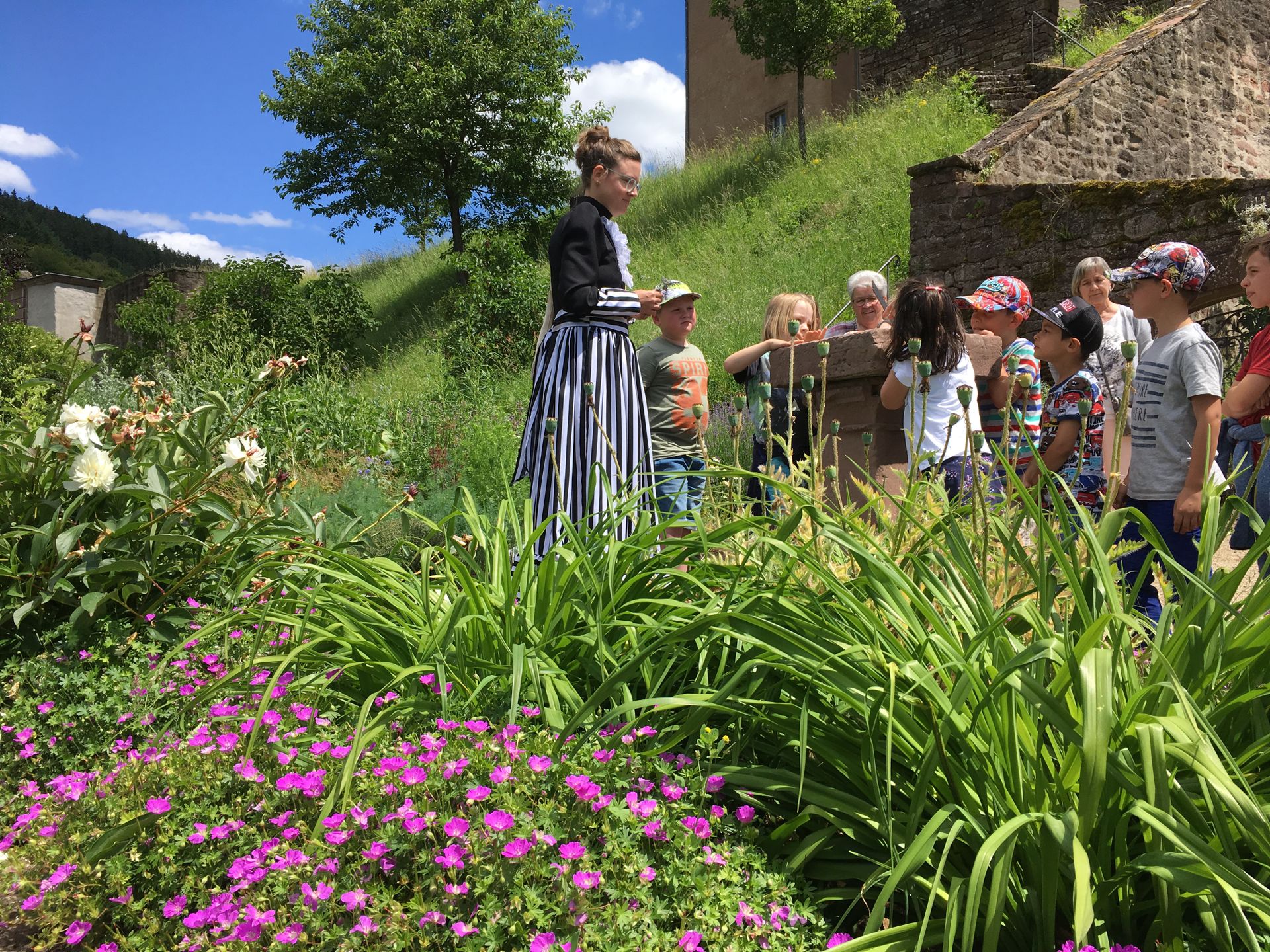 Kinder suchen einen Schatz auf Schloss Malberg. Sie befinden sich in einem Schlossgarten