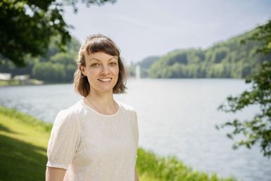 Die Mitarbeiterin Lioba Hamacher von der Tourist-Info Bitburger Land steht vor dem Stausee Bitburg