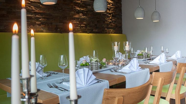 An elegant restaurant with covered tables and a cozy atmosphere. Candles and decorative details give the room a special charm.