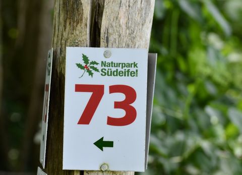Wandermarkierung der Route Naturpark Nr. 73. Rote Zahl auf weißem Grund