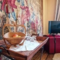 Une planche en bois rustique avec un panier plein de pommes et des verres se trouve devant une tapisserie. En arrière-plan, on peut voir une télévision.