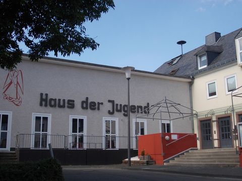 A building with the inscription "House of Youth". It is designed in a modern style and features an inviting entrance area.