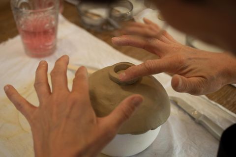 Deux petites maisons en céramique blanches avec des fenêtres en forme de cœur. Elles se trouvent sur un fond à motifs colorés.