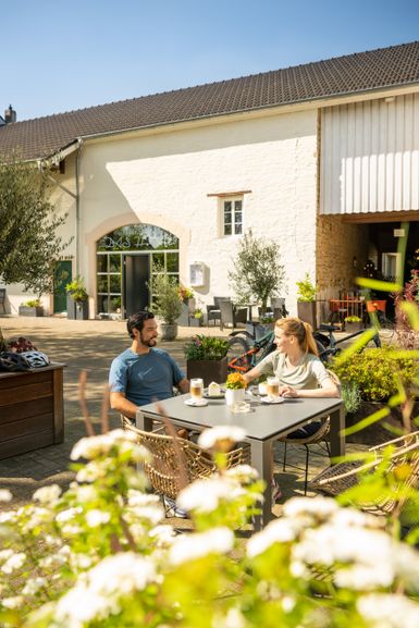 ein Mann und eine Frau machen bei Sonnenrast in einem Cafe. Sie sitzen draußen