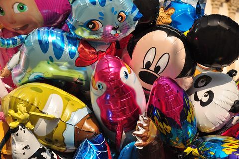 Colorful, inflated balloons in various shapes and forms are stacked on top of one another. They depict well-known characters and animals that radiate joy and festivity.
