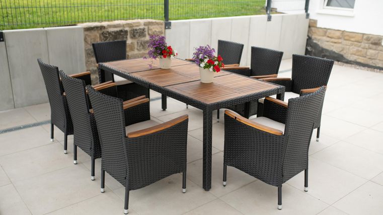 Een elegante eettafel van hout met acht stoelen op het terras voor gezellige middagen of barbecue-avonden.