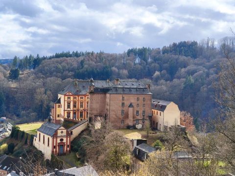 Un vieux château sur une colline, entouré d'arbres et d'un paysage pittoresque. Le ciel est nuageux et confère à la scène une atmosphère mystérieuse.