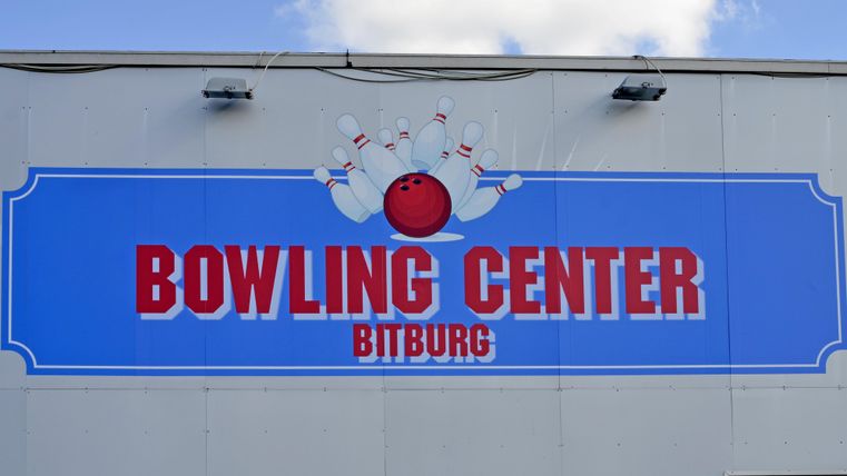 Een bord van het Bowlingcentrum in Bitburg. Het toont een rode bowlingbal en kegels op een blauwe achtergrond.