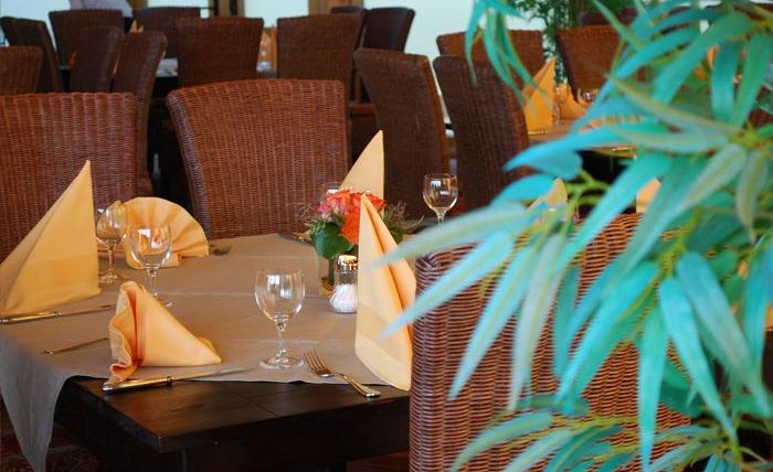 Ein elegantes Restaurant mit schön gedeckten Tischen. Die Einrichtung ist gemütlich und sorgfältig dekoriert.