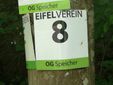 Ein Schild des Eifelvereins mit der Nummer 8 an einem Baum.
