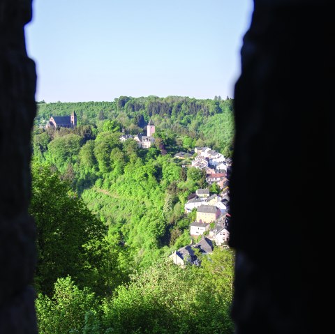 Blick von der Mariensäule auf eine grüne Landschaft mit Kirche und Häusern, umgeben von Wald und blauem Himmel., © Tourist-Information Bitburger Land_Monika Mayer
