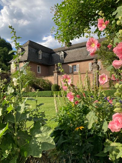 Eiserner Garten von Schloss Malberg. Brunnen mit Blumen davor