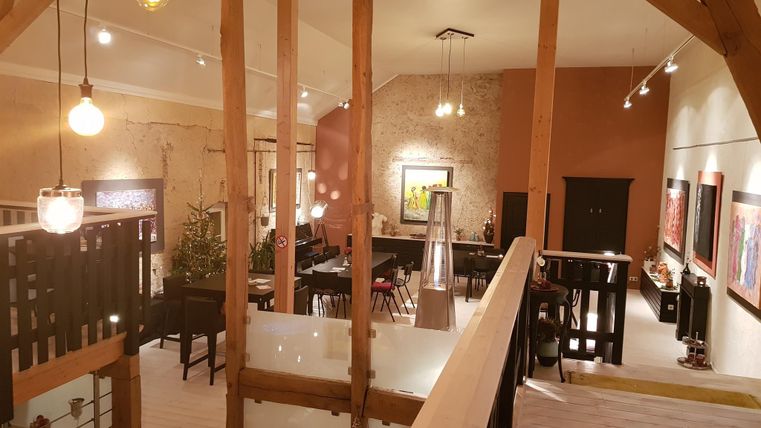 Ein stilvolles, modernes Wohnzimmer mit hohen Decken und Holzdetails. Der Raum ist gut beleuchtet und bietet eine gemütliche Atmosphäre.