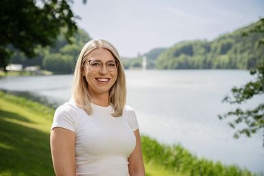 Die Mitarbeiterin Julia Retzlaff von der Tourist-Info Bitburger Land steht vor dem Stausee Bitburg