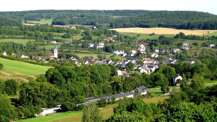 Landschaftsansicht von Oberweis mit Kirche und umliegenden Feldern.