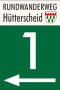 Wegwijzer voor de rondwandeling Hütterscheid met een groot wit cijfer 1 en een pijl die naar links wijst op een groene achtergrond., © VDM