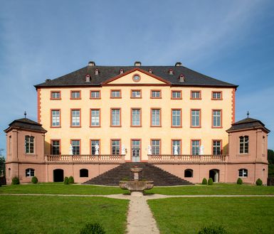 Schloss Malberg von vorne mit einem Brunnen.