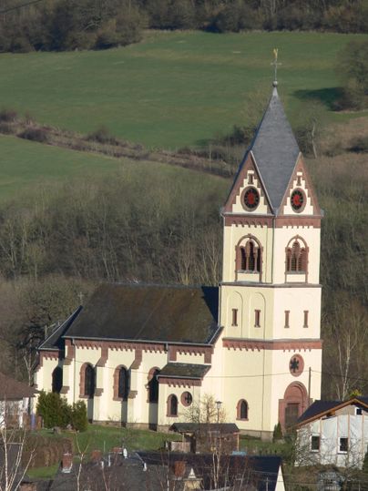 Eine Kirche mit einem hohen Turm in einer ländlichen Umgebung.