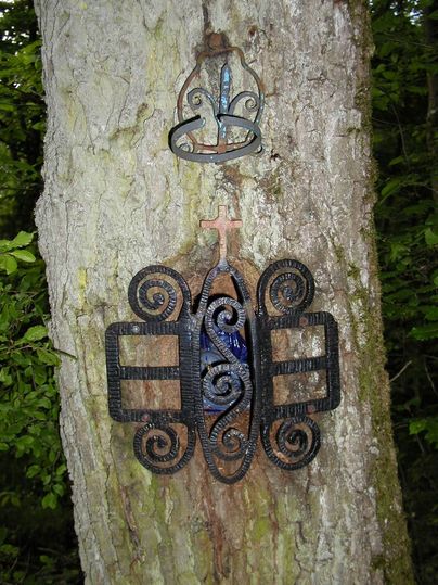 Ein Baum mit einer metallenen Verzierung und einem Kreuz.