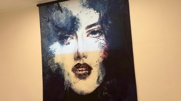 Een modern kunstwerk met het gezicht van een vrouw. De kleuren zijn donker en intens, wat het beeld een dramatische sfeer geeft.