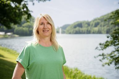 Die Mitarbeiterin Uschi Hallet von der Tourist-Info Bitburger Land steht vor dem Stausee Bitburg