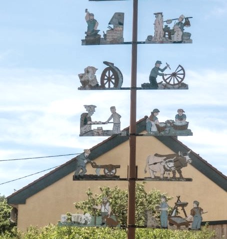 Een meiboom met handgemaakte figuren staat voor een huis in Trimport. Straatnaambord: Teitelbacher Straße., © TI Bitburger Land