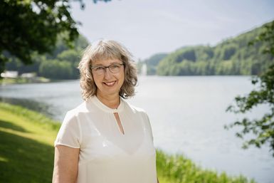 Die Mitarbeiterin Doris Welter von der Tourist-Info Bitburger Land steht vor dem Stausee Bitburg