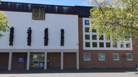 Un bâtiment moderne avec une façade frappante et des éléments artistiques. Les fenêtres et les sculptures donnent à l'édifice une note intéressante.