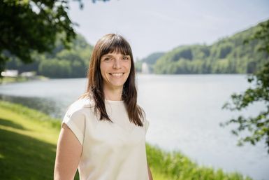 Die Mitarbeiterin Monika Mayer von der Tourist-Info Bitburger Land steht vor dem Stausee Bitburg