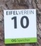 Trail marker of the Eifelverein with the number 10 and the text 'OG Speicher' on a tree., © Eifelverein Speicher