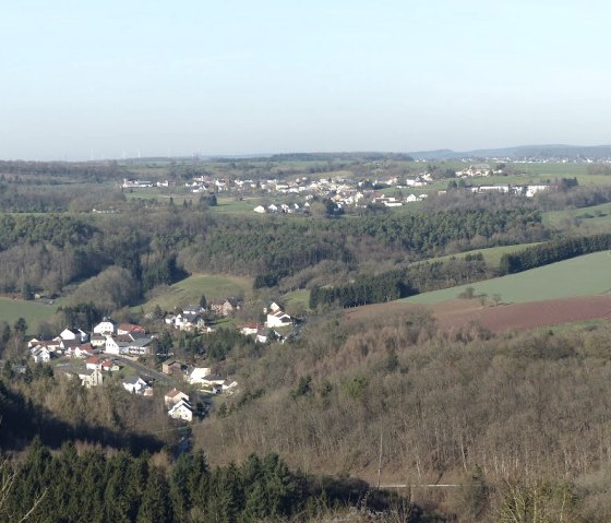 Panoramablick auf Philippsheim mit verstreuten Häusern, Feldern und Wäldern unter klarem Himmel., © Eifelverein Ortsgruppe Speicher