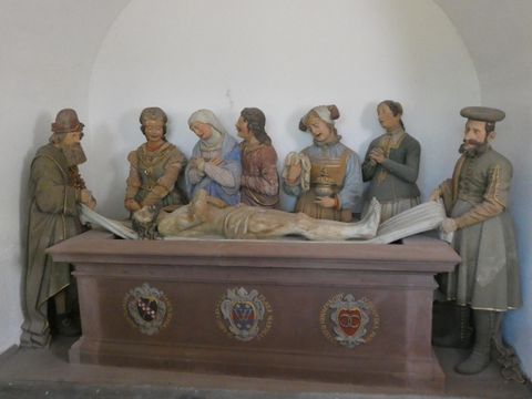 Een groep figuren die een Bijbelse scène uitbeelden. Ze staan rondom een ligbed met een mannelijke figuur die dood lijkt te zijn.