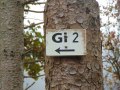 A tree with a sign "Gi 2" and an arrow pointing to the left. Blurred leaves can be seen in the background., © Conny Meier