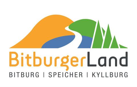 Ein Bus steht an der Straßenecke vor Wohnhäusern. Herbstliche Bäume sind in der Umgebung sichtbar.