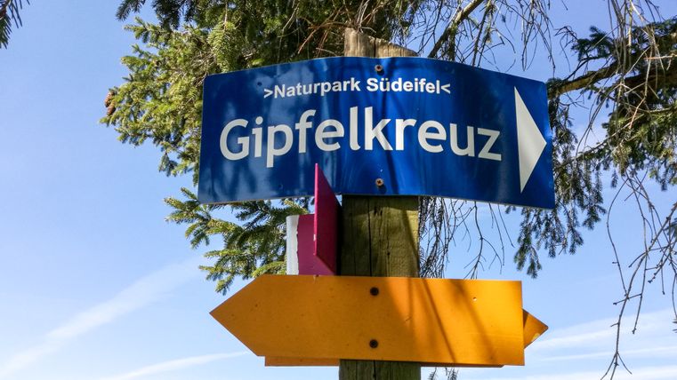 Wegweiser zum Gipfelkreuz im Naturpark Südeifel.